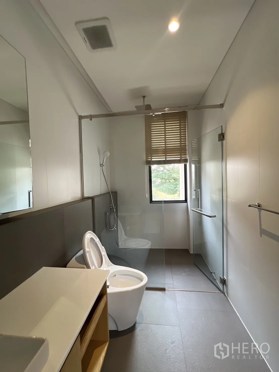 Detached House for rent in Suan Luang, Bangkok - Long bathroom with walk‑in shower, toilet spray and vanity.