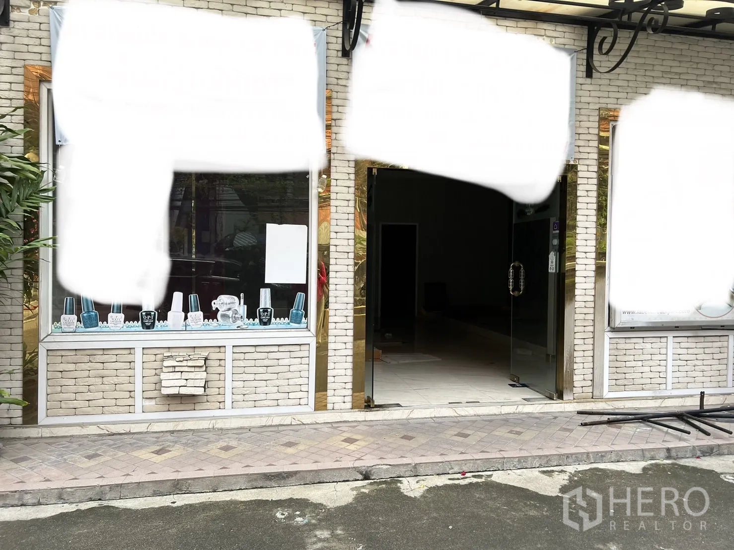 零售空间 出租在Khlong Toei, Bangkok - 商铺入口特写，双开玻璃门与展示橱窗，门前铺装人行道。