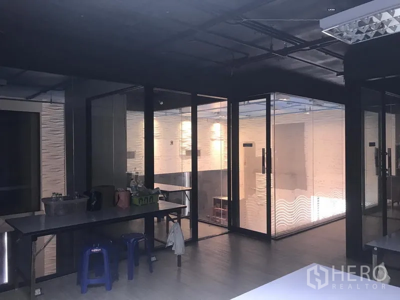 零售空间 出租在Khlong Toei, Bangkok - 零售室内空间，带玻璃隔间、外露天花与工作台区域。