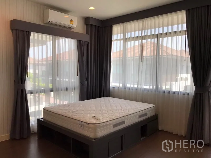 Detached House for rent in Bang Kapi, Bangkok - Corner bedroom with windows on three sides, blackout drapes and storage bed.