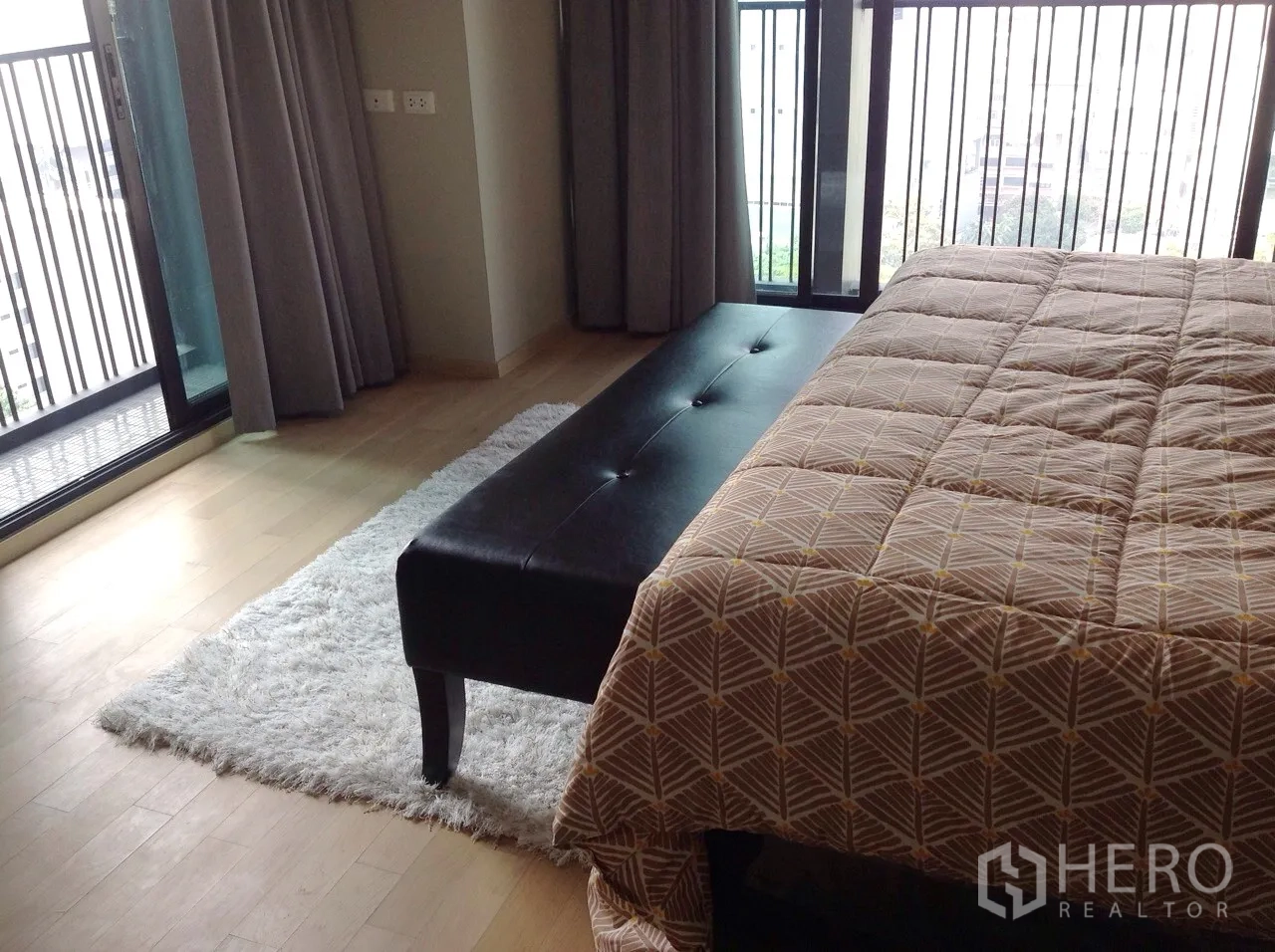 公寓 出租或出售在Watthana, Bangkok - 卧室一角，长凳、长绒地毯和落地阳台门。