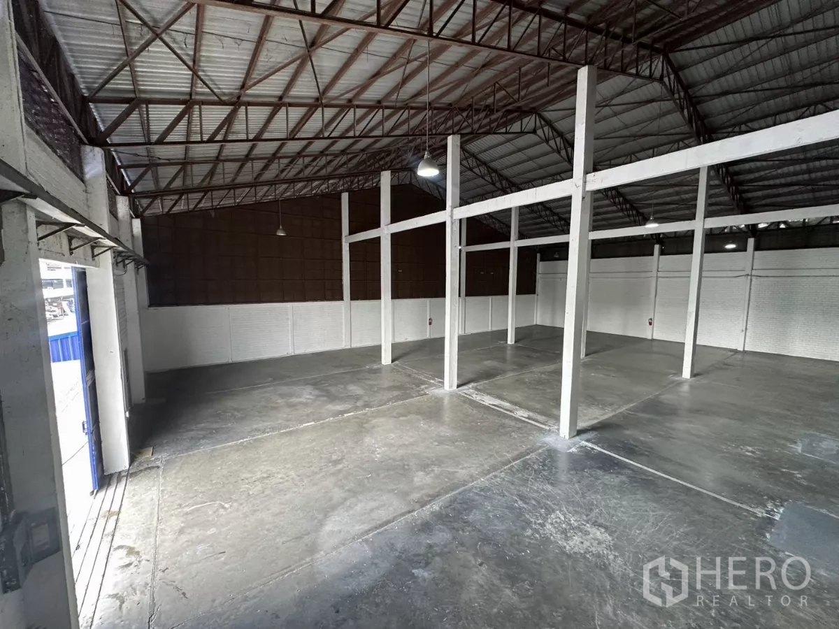 Warehouse for rent in Phra Khanong, Bangkok - Warehouse interior near the loading entrance with natural light and steel truss roof.