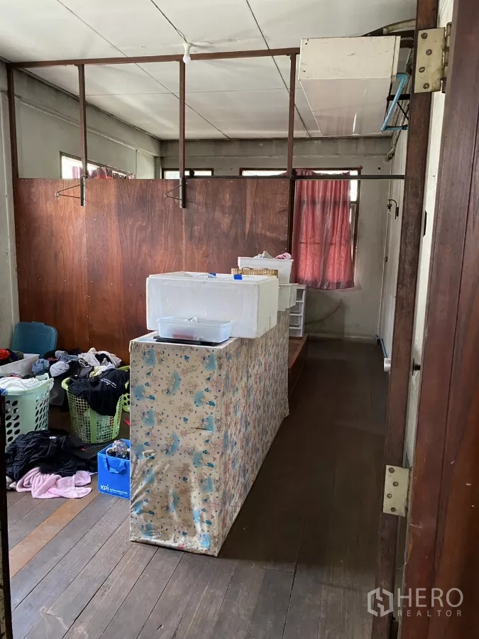 Shophouse for rent in Khlong Toei, Bangkok - Upper floor room with wooden flooring and windows, used for storage.