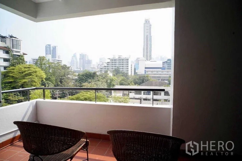 คอนโด ให้เช่าในWatthana, Bangkok - ระเบียงมีเก้าอี้หวายสองตัว มองเห็นวิวเมืองและต้นไม้ของกรุงเทพฯ