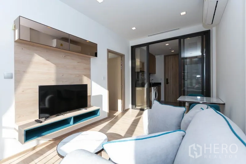 Condominium for rent in Watthana, Bangkok - View from sofa toward TV wall, dining table and glass partition to the kitchen.