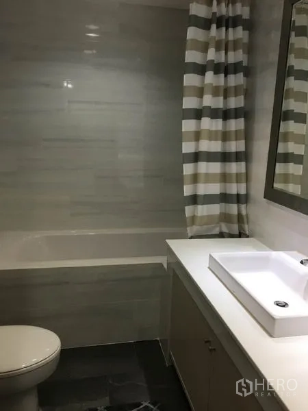 公寓 出租在Watthana, Bangkok - 浴室配浴缸、条纹浴帘与方形台上盆