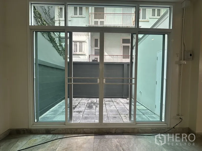 带办公室的家 出租在Khlong Toei, Bangkok - 落地推拉门连接私密的后部铺砖小庭院。