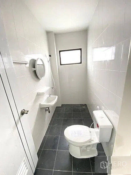 Factory for rent in Bang Bua Thong, Nonthaburi - Clean tiled bathroom with shower, toilet and small window.