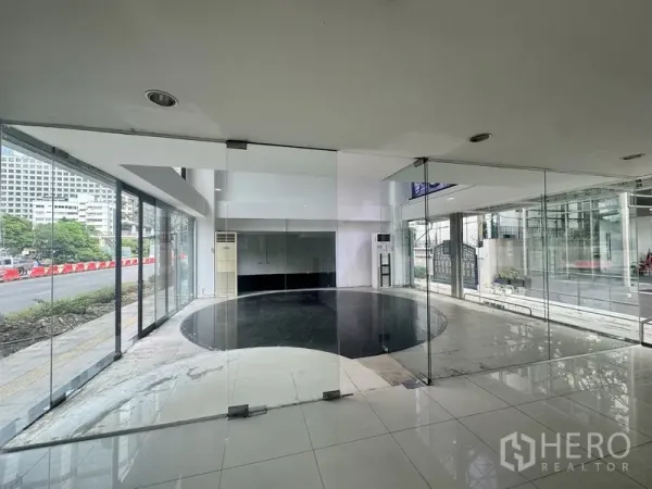 零售空间 出租在Sathon, Bangkok - 双层挑高展厅，落地玻璃与圆形黑色地砖，临街视野开阔。