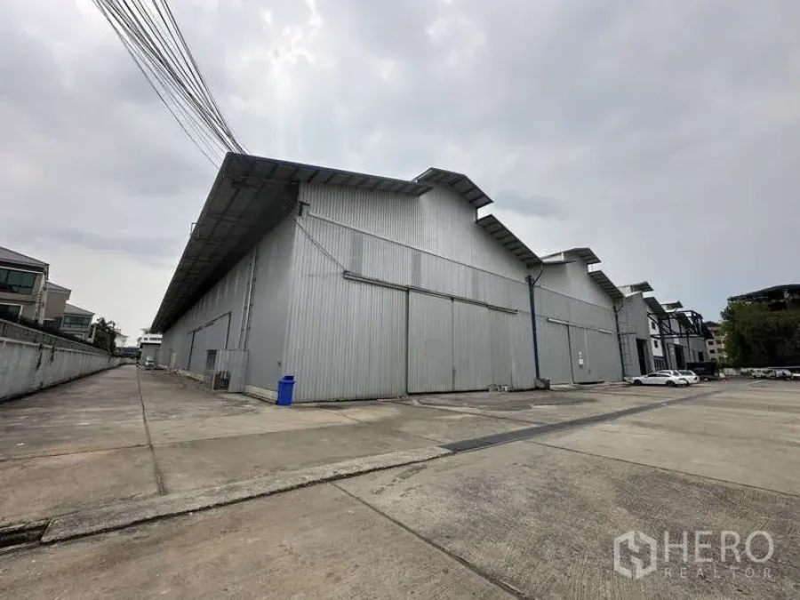 货栈 出租在Pak Kret, Nonthaburi - 大型金属板仓库外观，带宽阔车道与装卸场地。