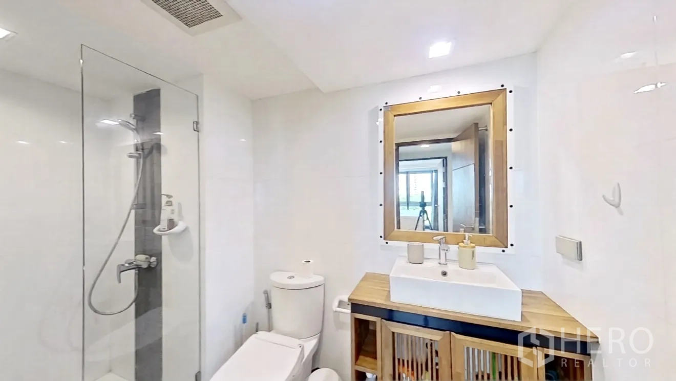 คอนโด for rent in Watthana, Bangkok - ห้องน้ำสว่างพร้อมตู้กระจกกั้นอาบน้ำ โถสุขภัณฑ์ และเคาน์เตอร์ไม้พร้อมกระจก