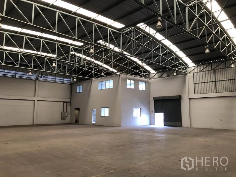 Factory for rent in Pathum Thani - Open production floor with steel truss roof, internal office and loading bays.