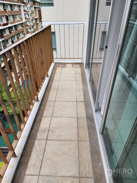 Condominium for rent in Watthana, Bangkok - Narrow balcony with tiled flooring and sliding glass doors.