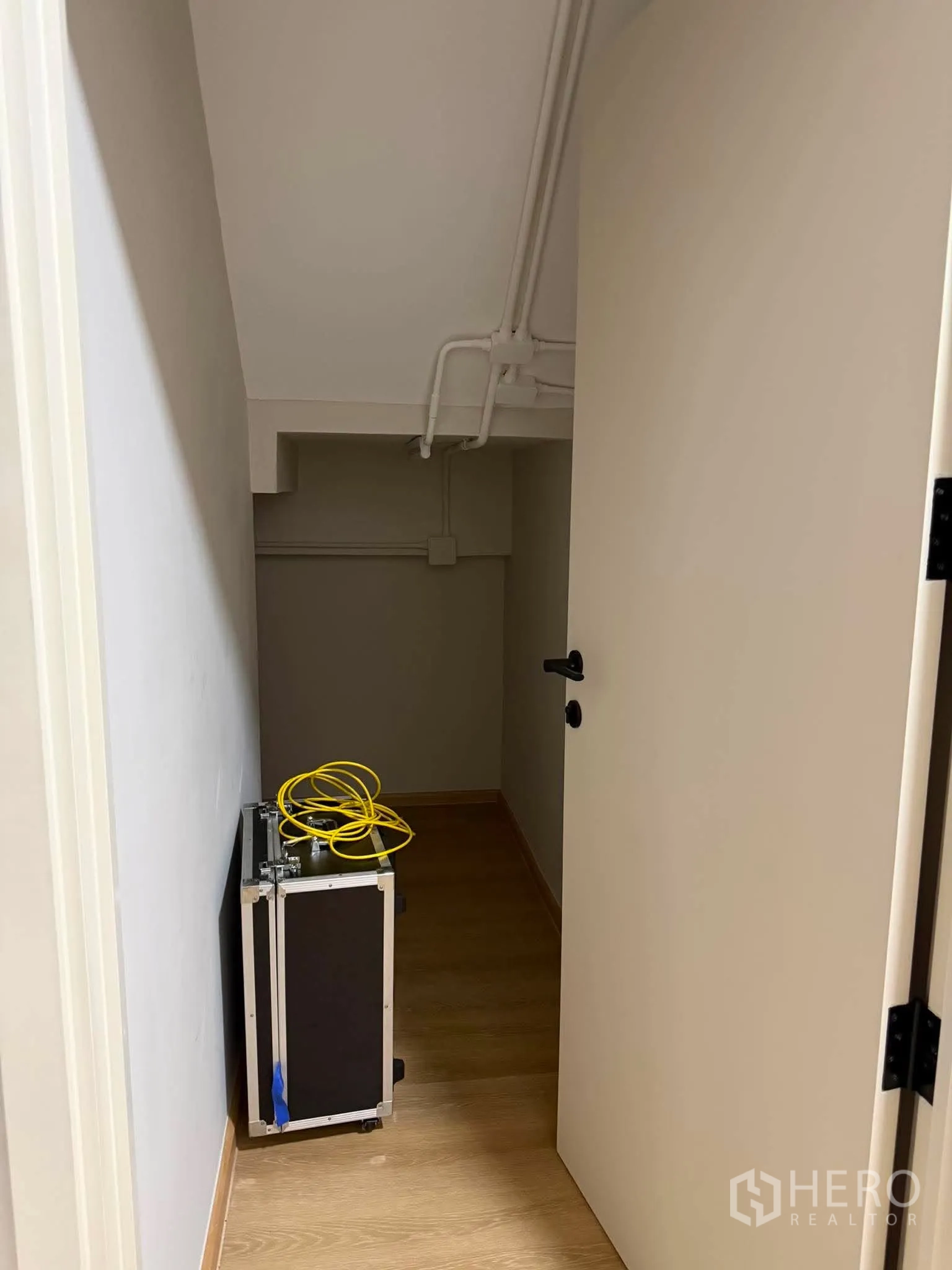 家庭办公室 for rent in Phra Khanong, Bangkok - 楼梯下储物间，外露管线与木地板。