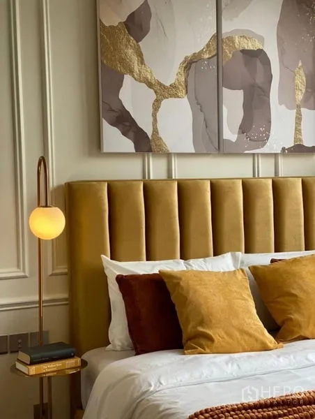 Condominium for rent - Detail of mustard velvet headboard with modern wall art and round globe lamp.