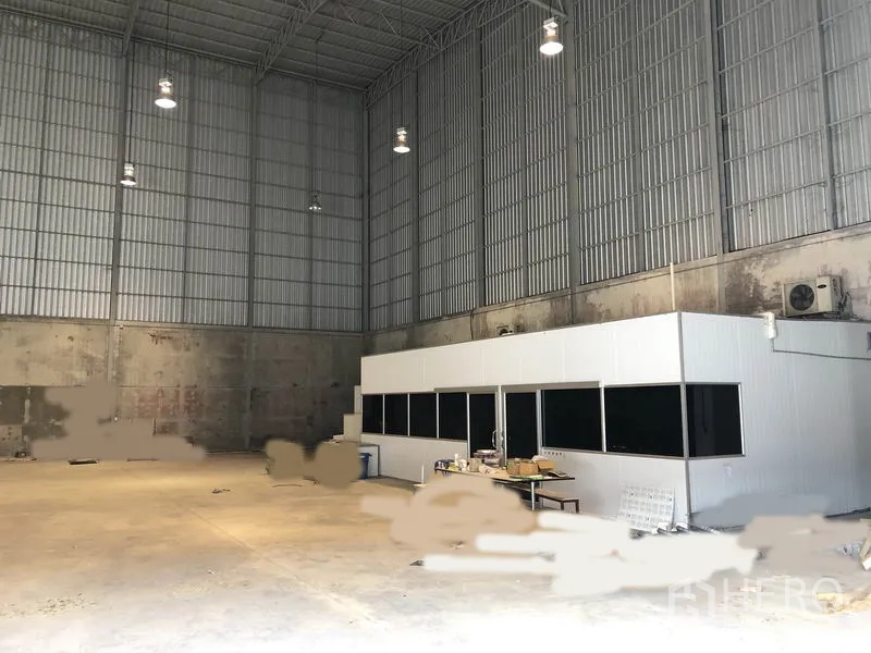 Warehouse for rent in Lam Luk Ka, Pathum Thani - Spacious warehouse interior with very high steel ceiling and a built-in glass-front office unit.