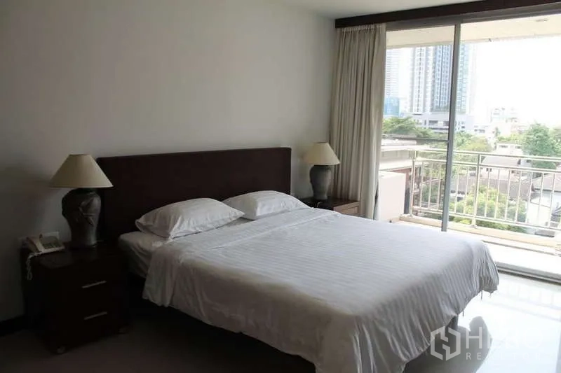 Condominium for rent in Sathon, Bangkok - Bright bedroom with double bed, bedside lamps, and sliding doors to a balcony with city views.