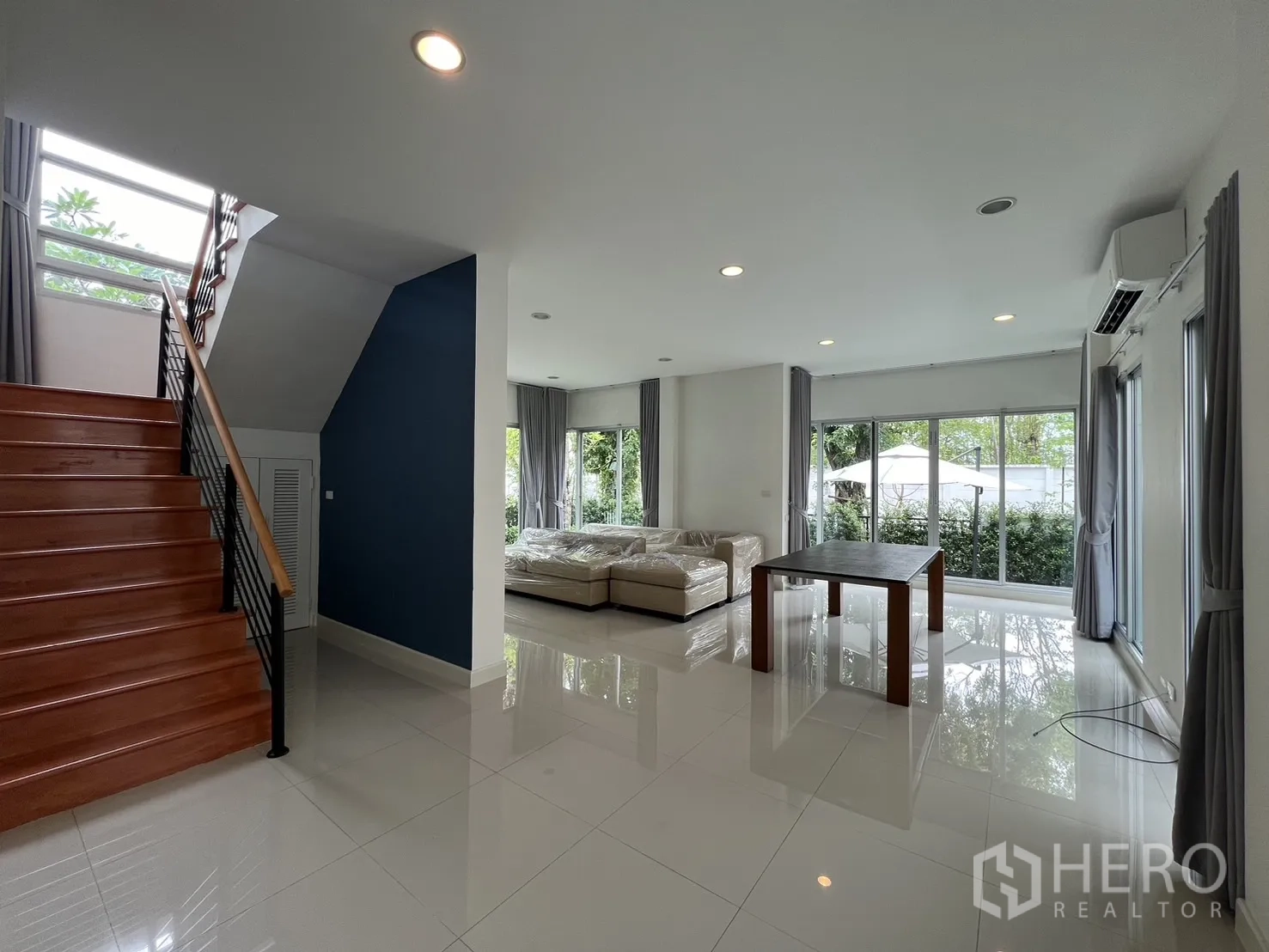 Detached House for rent in Saphan Sung, Bangkok - Bright open‑plan living area with staircase, sofa and dining table.