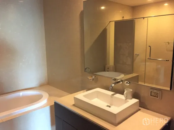 公寓 出租在Watthana, Bangkok - 现代浴室，设浸泡浴缸、玻璃淋浴间、宽大台盆与大镜面。