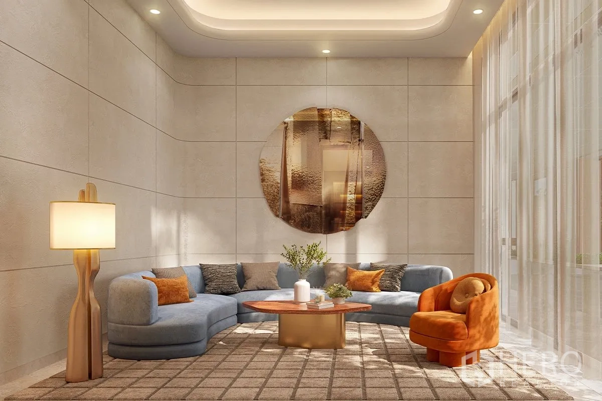 Condominium for sale in Watthana, Bangkok - Elegant double-height lounge with curved sofa, orange accent chair, coffee table, and soft lighting.