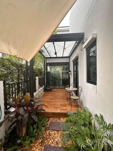 联排别墅 出售在Wang Thonglang, Bangkok - 木质露台，张拉篷与绿植，可通厨房。