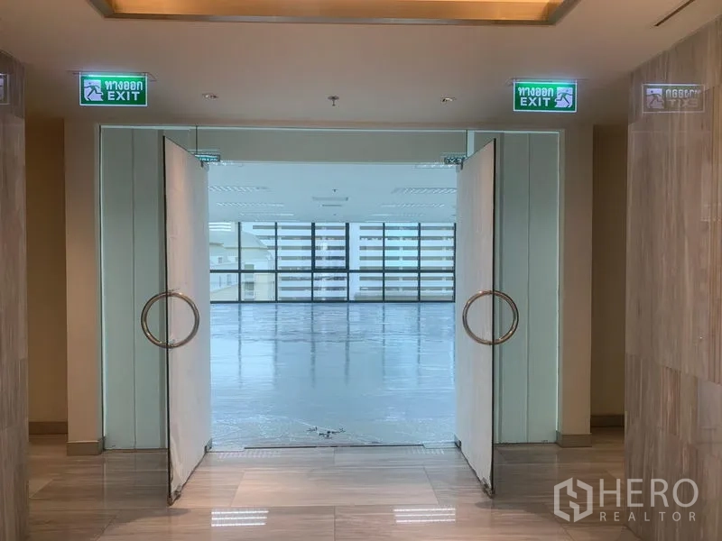 Office Space for rent in Bang Rak, Bangkok - Double glass doors opening to a bright open‑plan office floor with full windows ahead.