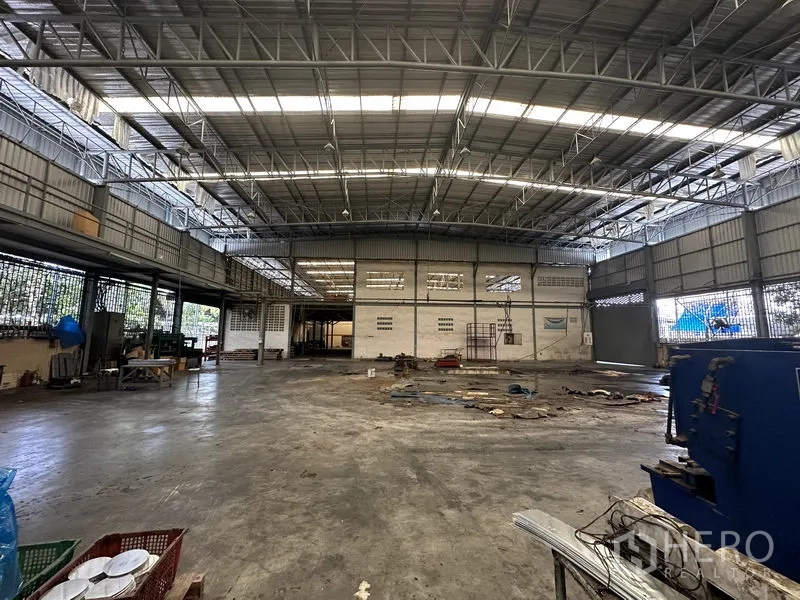 Factory for rent or sale in Lam Luk Ka, Pathum Thani - Wide-span shed with roller door, steel roof and open floor.