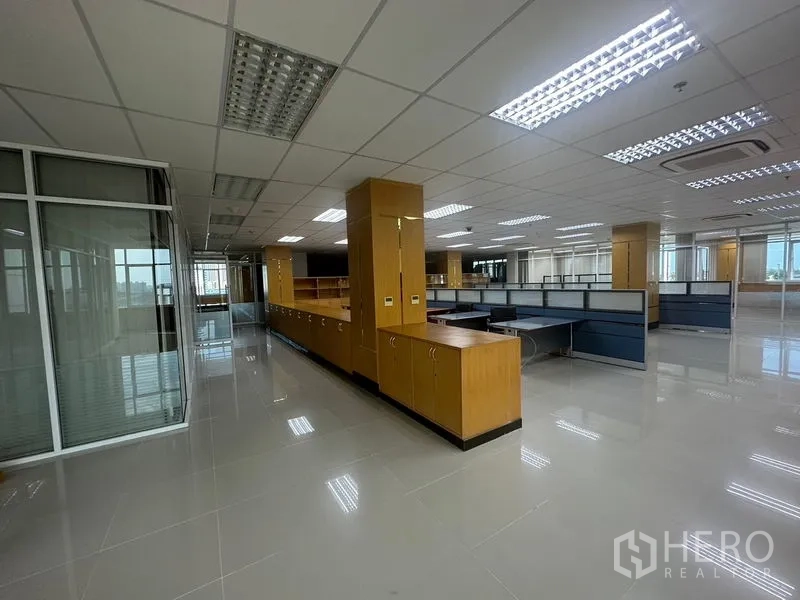 สำนักงาน ให้เช่าในSuan Luang, Bangkok - มุมมองทางเดินสู่พื้นที่สำนักงานแบบคูบิกเคิล พร้อมแสงสว่างเหนือศีรษะและตู้ไม้