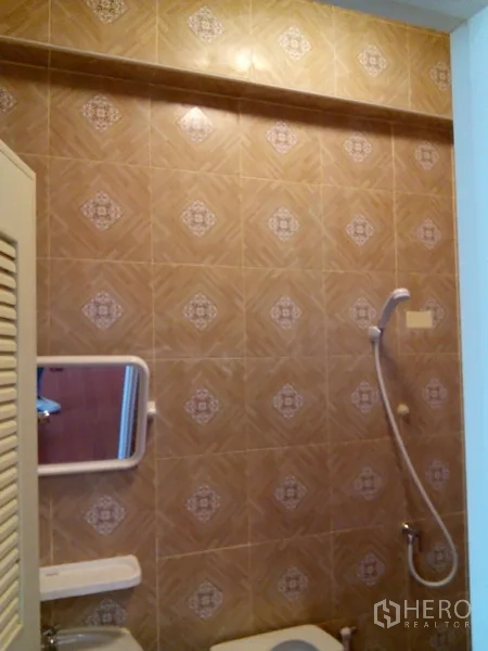 Shophouse for rent in Phra Khanong, Bangkok - Bathroom corner with mirror, sink and shower fittings.