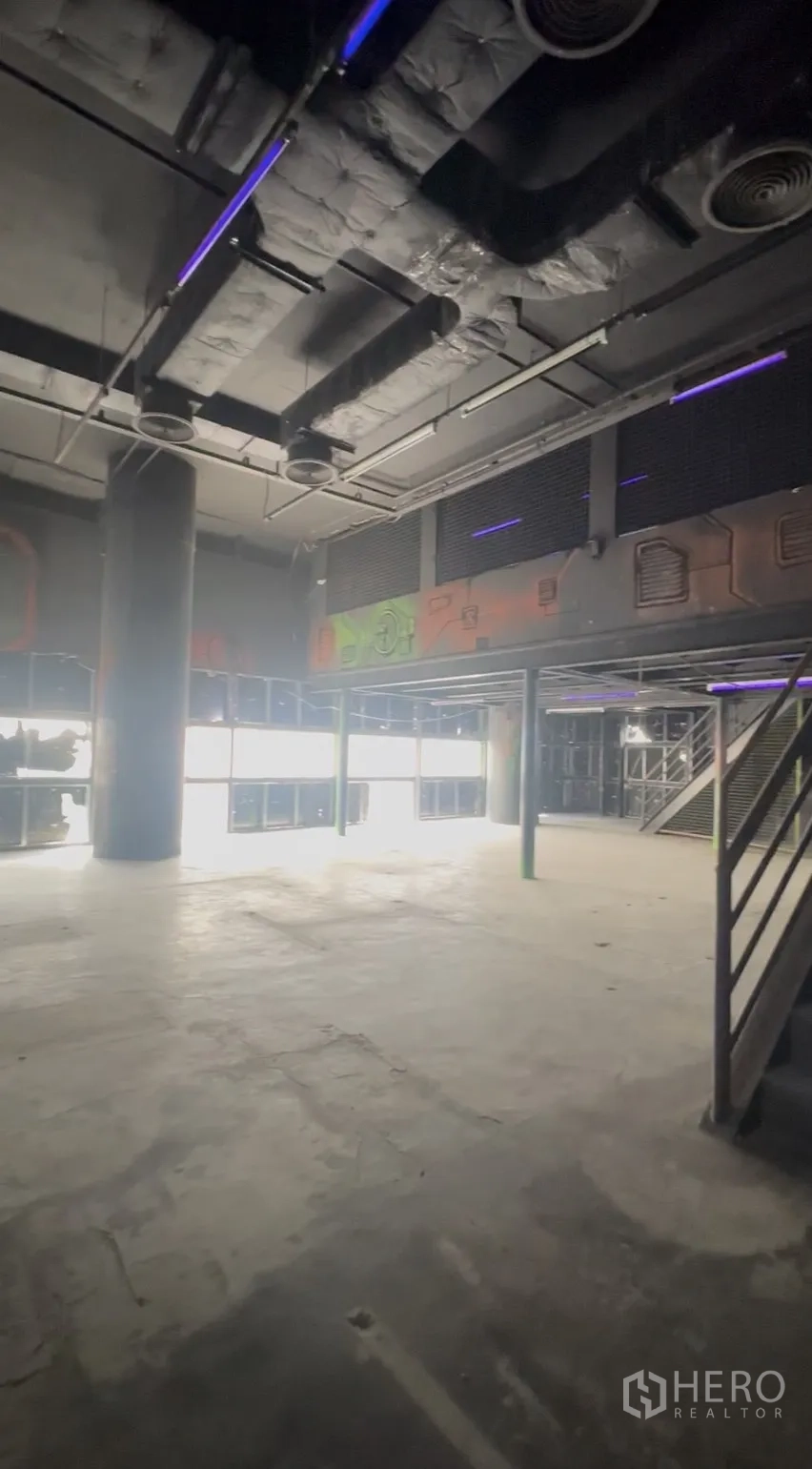 Retail Space for rent in Khlong Toei, Bangkok - High-ceiling retail area with central column, large windows and partial mezzanine.