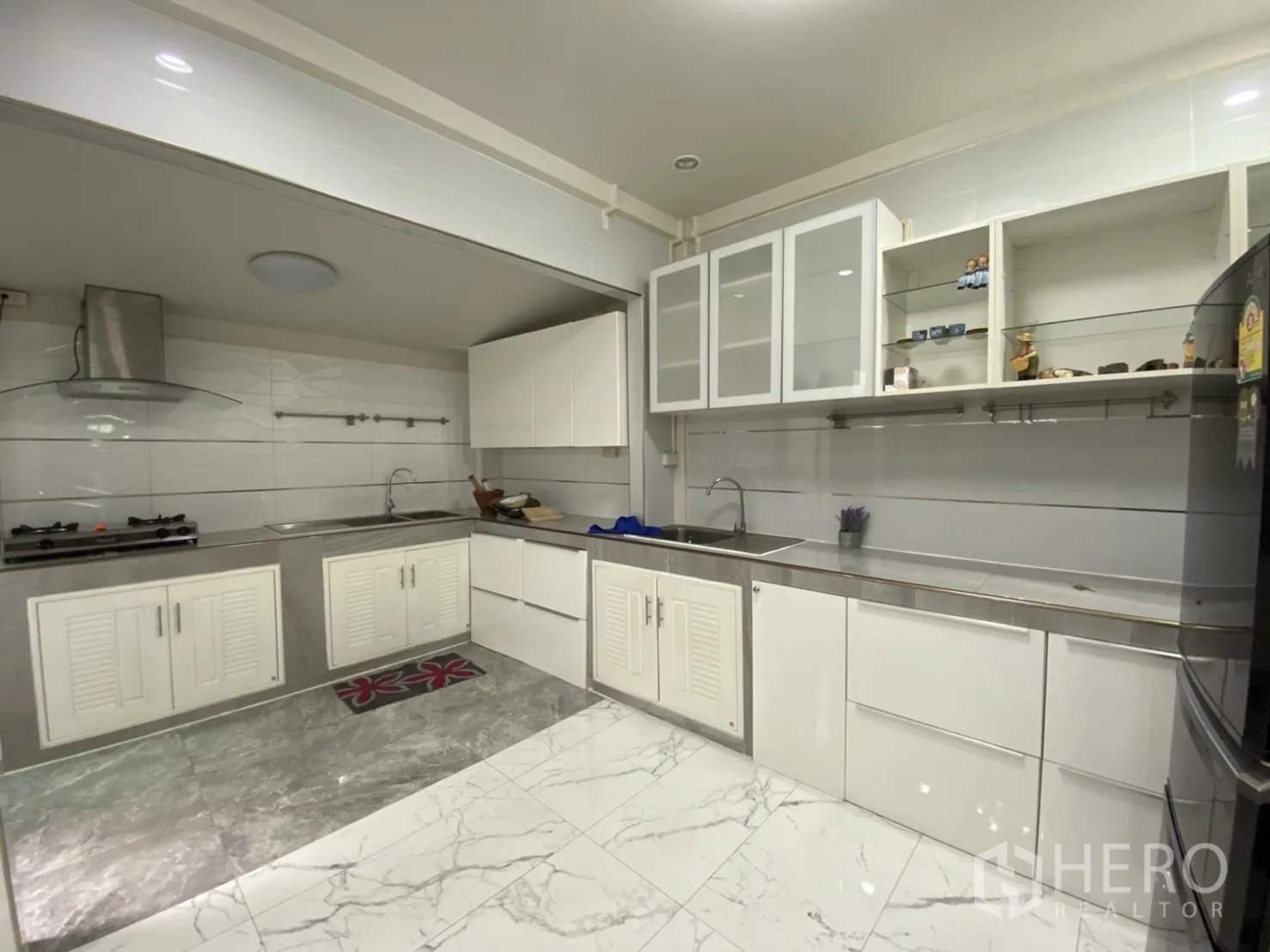 Townhouse for rent or sale - White built-in kitchen with gas hob, range hood and ample cabinetry.