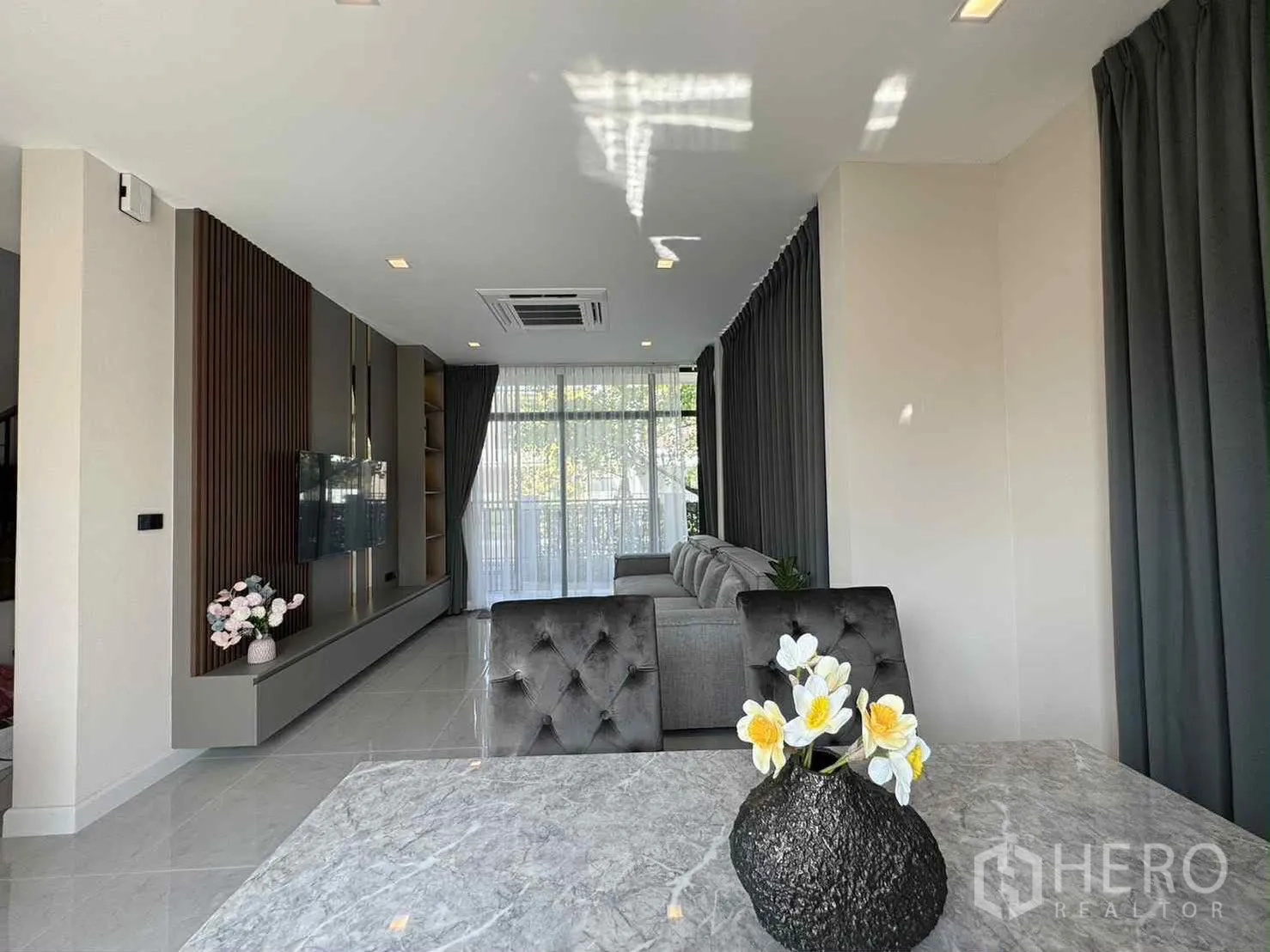 บ้านเดี่ยว for rent in Bang Phli, Samut Prakan - มุมรับประทานอาหารมองสู่ห้องนั่งเล่น ม่านทึบสูงเต็มผนัง และแอร์คาสเซ็ตติดฝ้า.