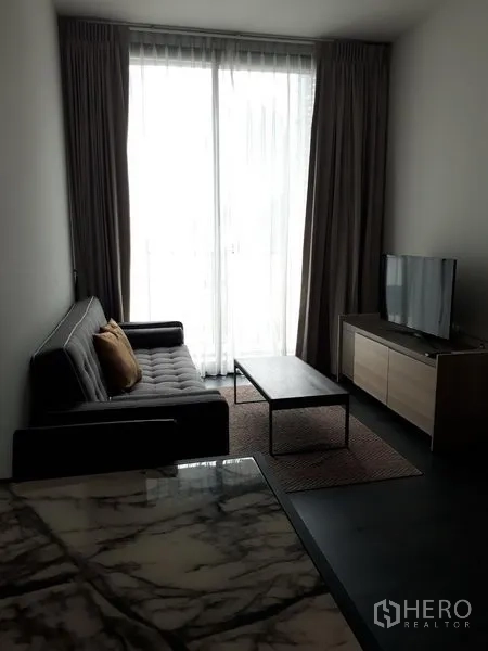 公寓 出租或出售在Watthana, Bangkok - 曼谷公寓客厅，落地窗配窗帘，沙发、茶几与电视柜，采光明亮，靠近Asok。