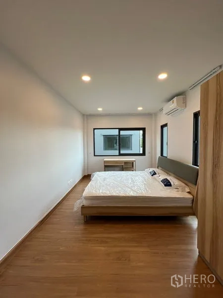 Detached House for rent or sale in Bang Phli, Samut Prakan - Guest bedroom with bed, wardrobe, air conditioner and multiple windows.