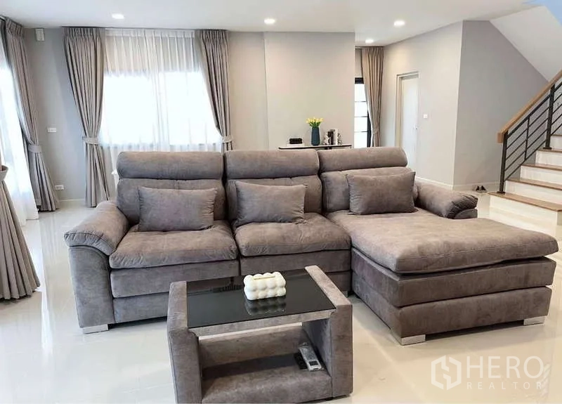 บ้าน ให้เช่าในBang Phli, Samut Prakan - ห้องนั่งเล่นโอเพนแปลนกับโซฟา L-Shape สีเทาขนาดใหญ่และบันได