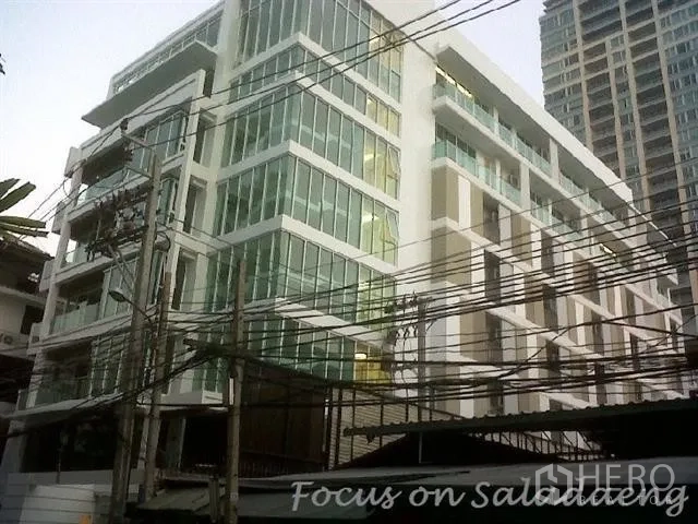 公寓 出租或出售在Bang Rak, Bangkok - 现代低层公寓外立面，配大面积玻璃窗。