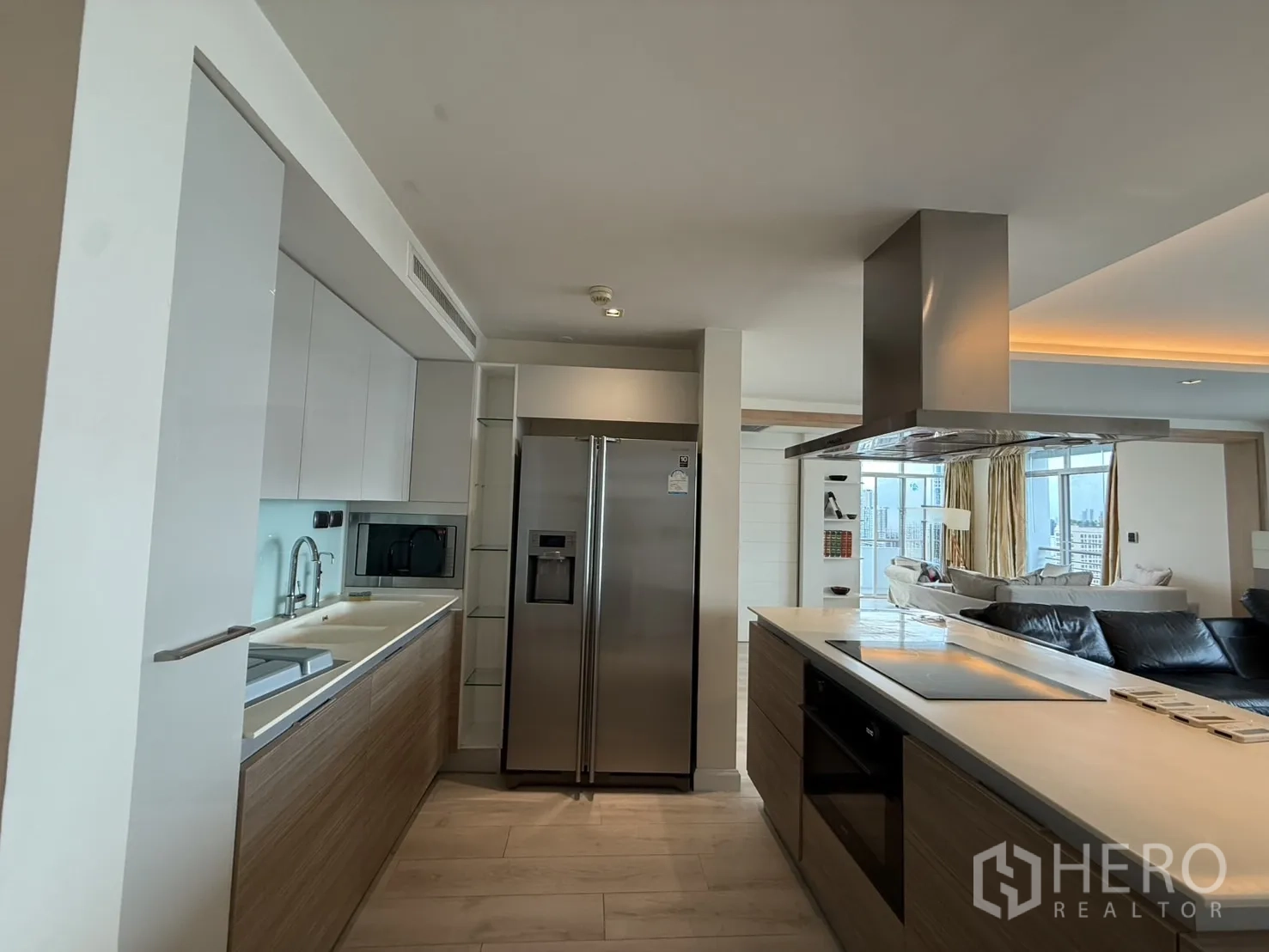 Condominium for rent in Phaya Thai, Bangkok - Contemporary kitchen with island, double‑door refrigerator and built‑in oven facing the living area.