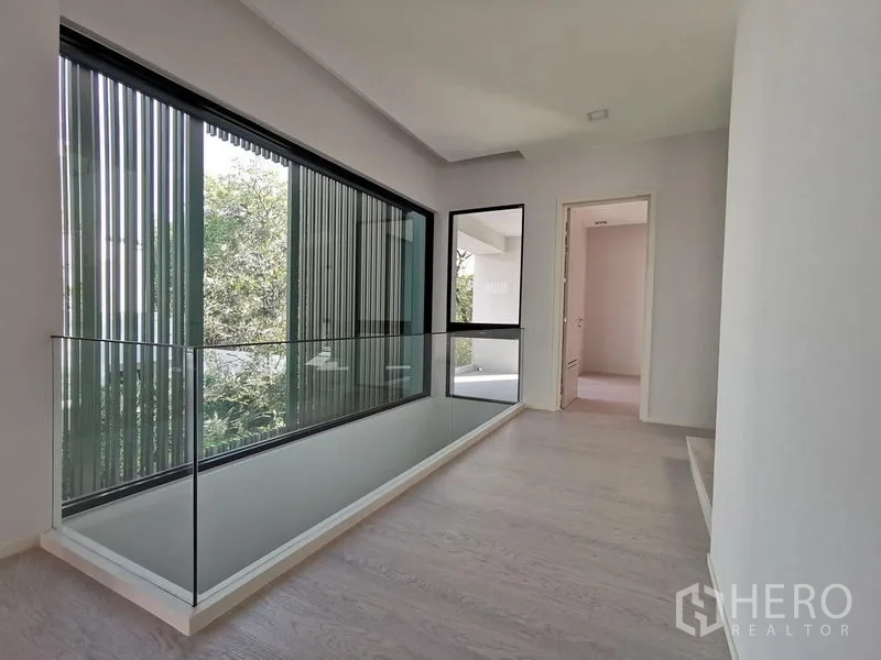บ้าน ขายในSaphan Sung, Bangkok - โถงชั้นบนราวกระจก มองเห็นสวนภายนอกผ่านมู่ลี่แนวตั้ง.