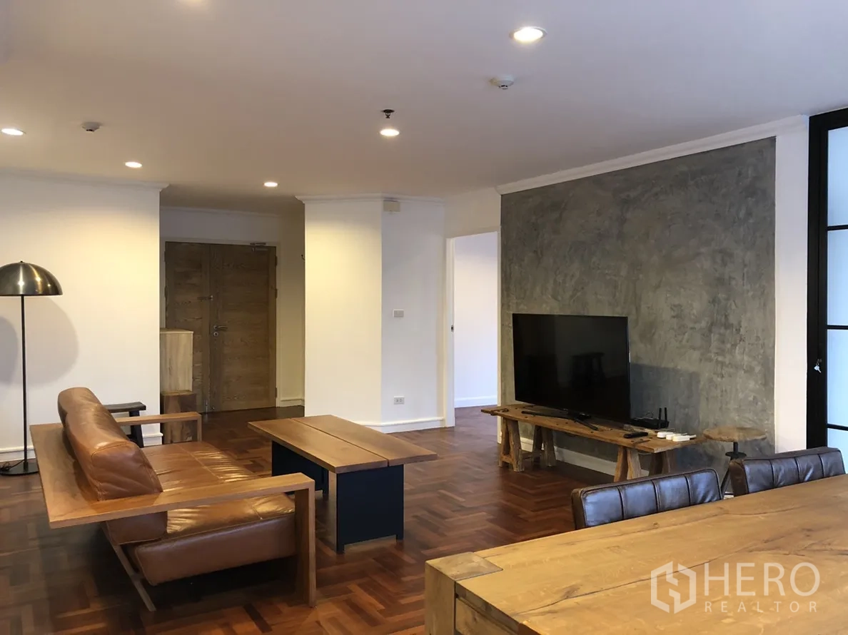 คอนโด ให้เช่าในWatthana, Bangkok - ห้องนั่งเล่นกว้าง ผนังคอนกรีตโชว์ลาย ทีวี และพื้นปาร์เกต์
