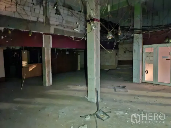 Shophouse for rent in Bang Rak, Bangkok - Ground-floor open space with concrete columns and exposed wiring ready for renovation.