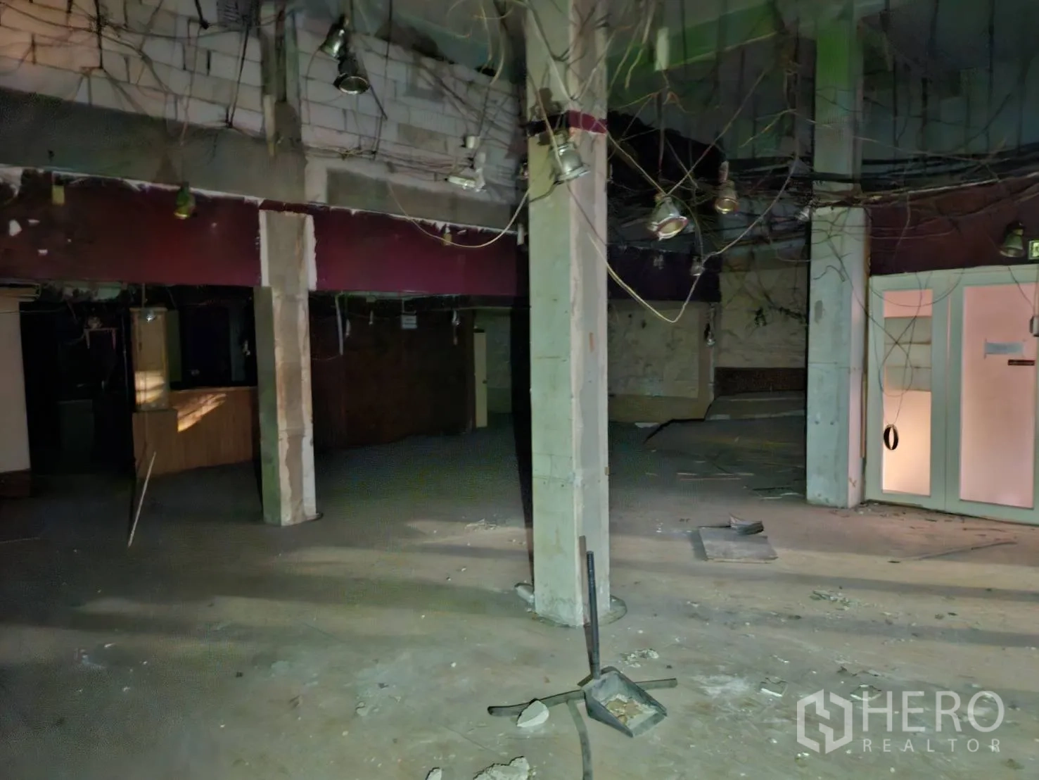 Shophouse for rent in Bang Rak, Bangkok - Ground-floor open space with concrete columns and exposed wiring ready for renovation.