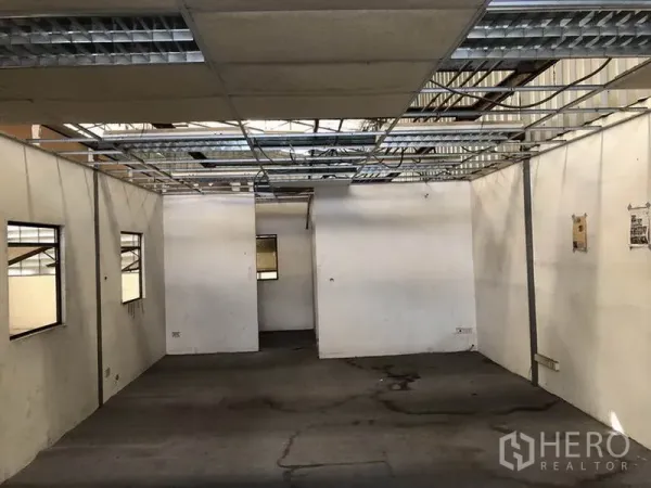 Warehouse for rent in Suan Luang, Bangkok - Partitioned office area under renovation with exposed ceiling grid and windows.