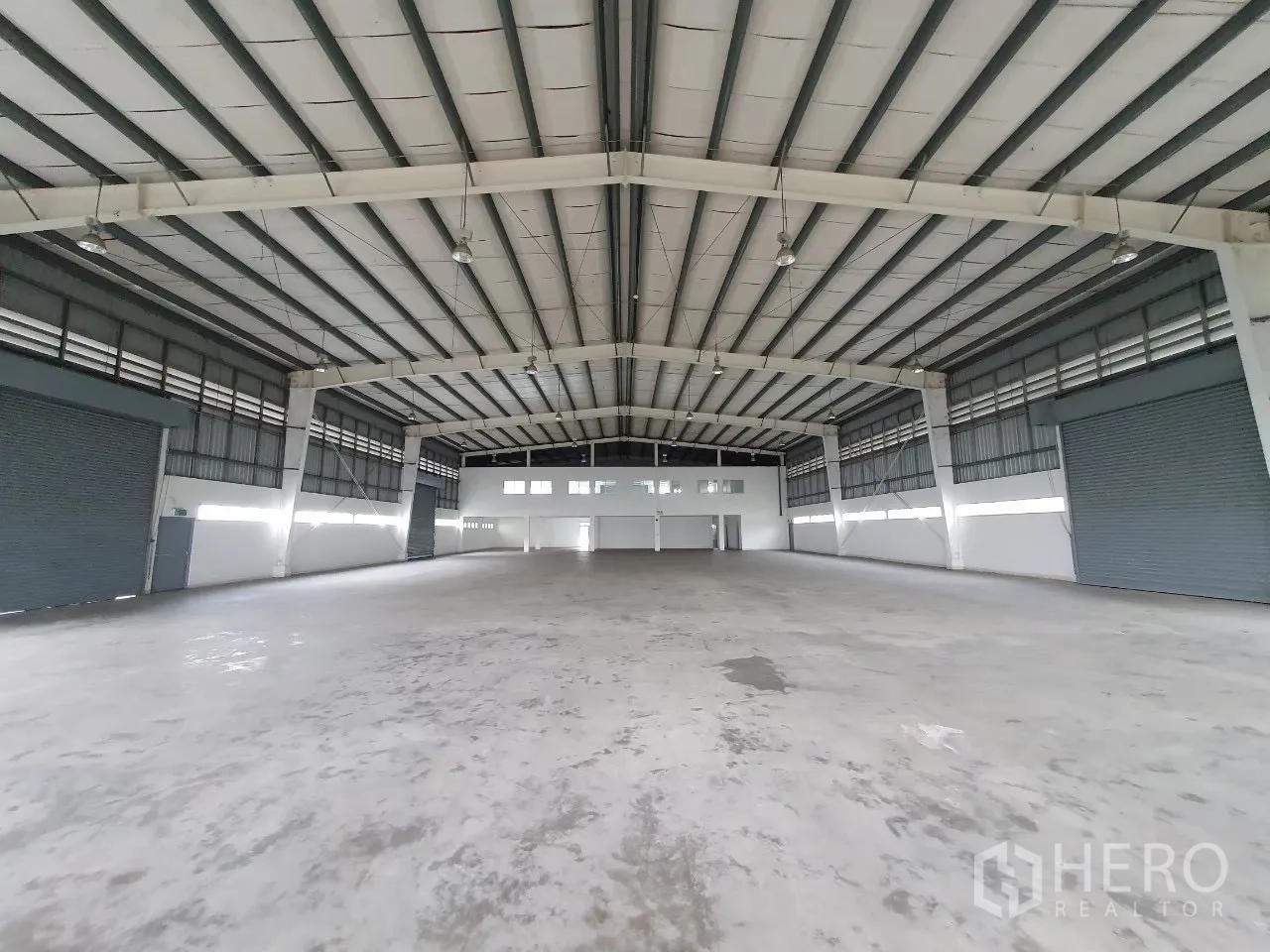 โรงงาน for rent in Bang Pa-in, Phra Nakhon Si Ayutthaya - โถงผลิตเปิดโล่งโครงหลังคาเหล็กและประตูม้วนหลายจุด.