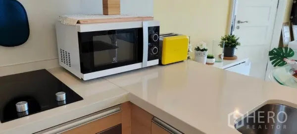 Condominium for rent or sale in Khlong Toei, Bangkok - Smooth countertop with microwave and toaster next to the electric hob.