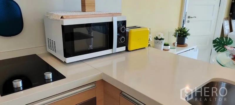 Condominium for rent or sale in Khlong Toei, Bangkok - Smooth countertop with microwave and toaster next to the electric hob.