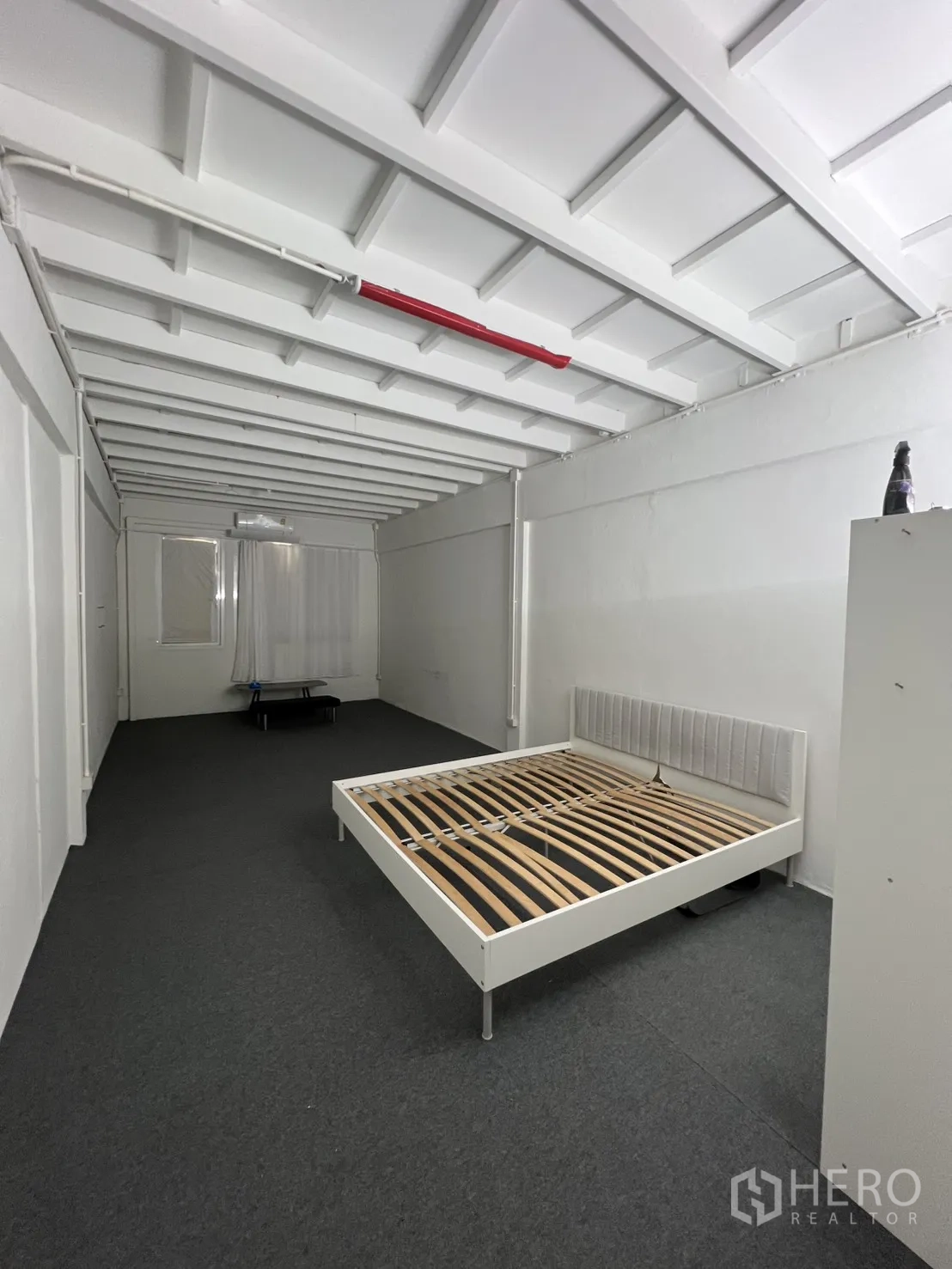 Shophouse for rent or sale in Khlong Toei, Bangkok - Large room with carpet and bed frame showing potential for studio or staff area.