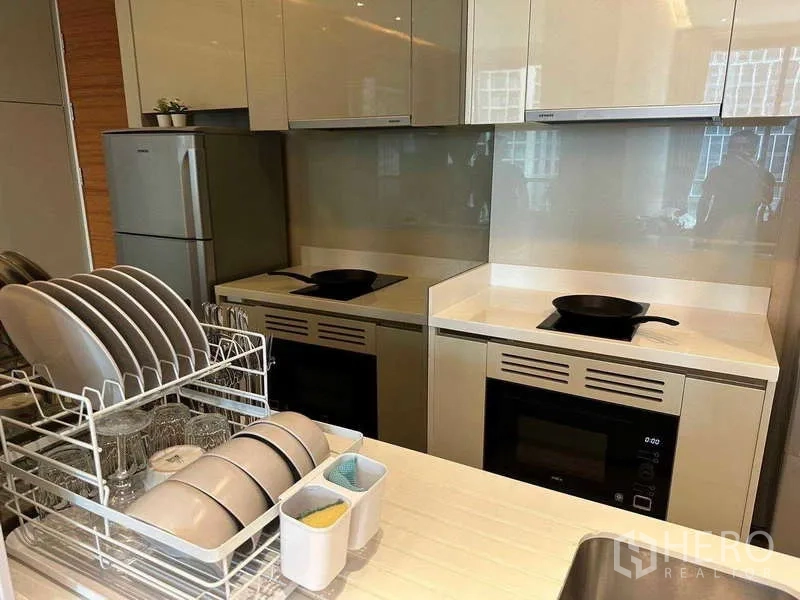 Condominium for rent or sale - Built-in kitchen with twin cooktops, ovens and a dish rack on the counter.