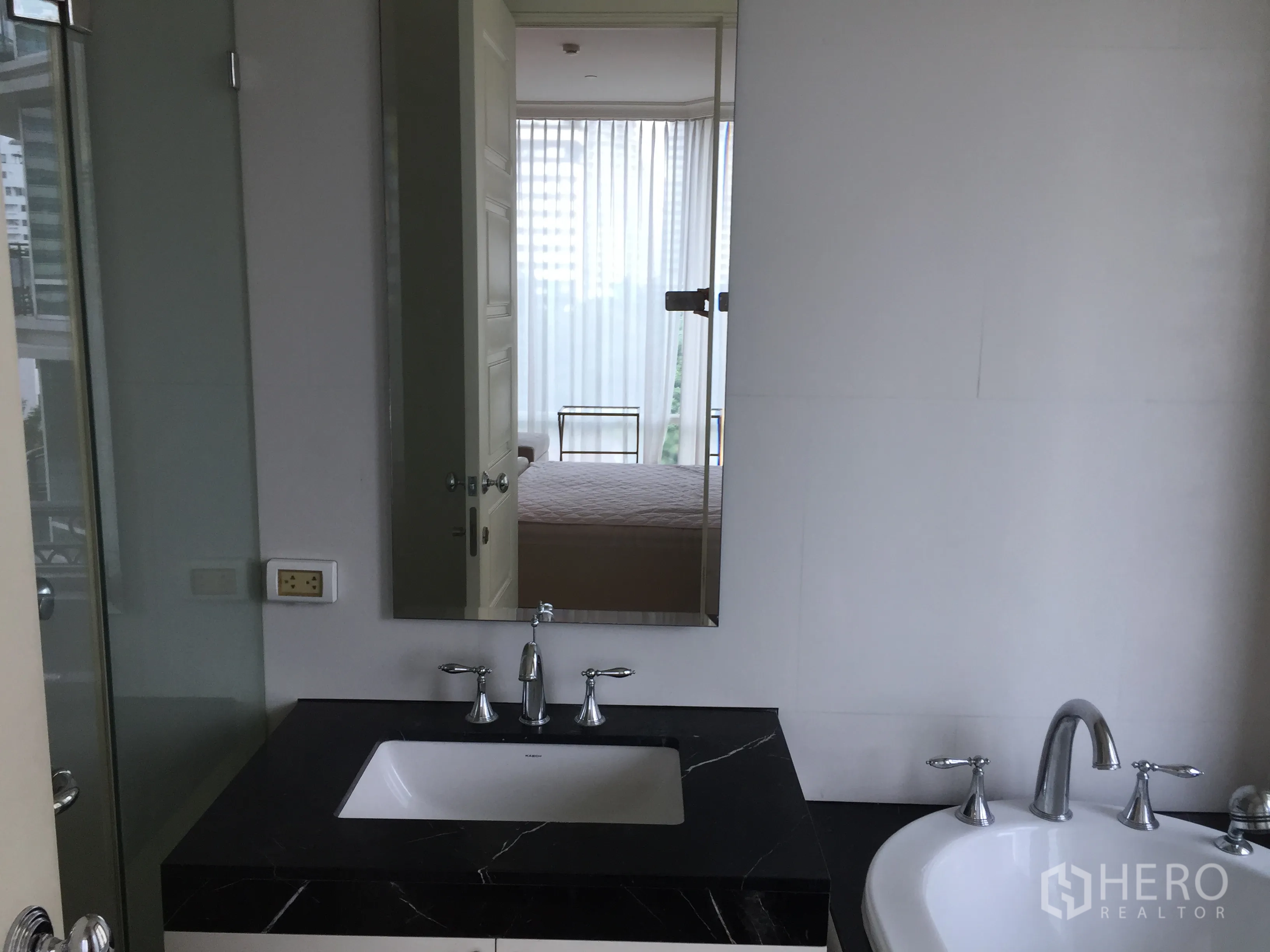 Condominium for rent in Watthana, Bangkok - Bathroom with black stone vanity, under-mount sink, bathtub and glass shower door.