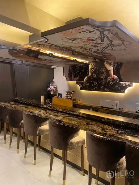 Shophouse for rent - Elegant marble-top bar counter with upholstered stools and decorative ceiling panels.