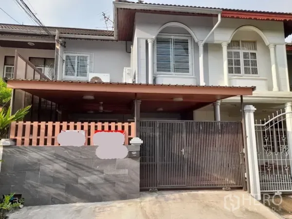 Townhouse for rent or sale - Two-storey townhouse facade with gated carport in Huai Khwang, Bangkok.